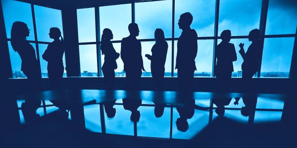 Cooperation Several colleagues communicating in office against window